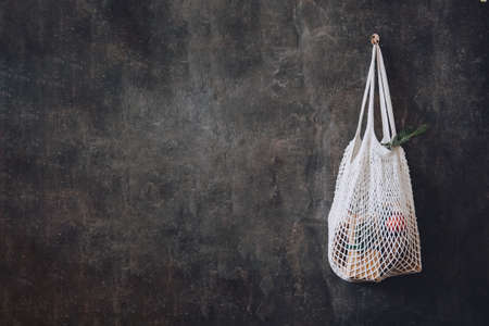 Zero waste, Sustainable, green, eco-friendly Christmas. Eco friendly mesh net shopping bag with craft gift boxes and green fir tree branch. Mesh Reusable Cotton Grocery Bag with Christmas giftsの写真素材