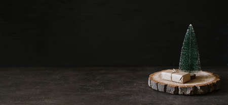 Christmas Banner, Xmas minimal background with craft gift boxes and cone toy Christmas tree on wooden dark background. Zero waste, Sustainable, green, eco-friendly Christmas Bannerの写真素材