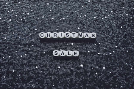 Christmas sale words on new year black night fabric tulle, background with silver glitter star. Christmas sale dark backdrop with shine star sequinの写真素材