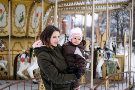 Best Outdoor Winter Activities with Baby. Baby toddler in Winter, How to Protect kids in Cold Weather. Mother and baby girl daughter walking in the winter parkの写真素材