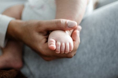 Health Insurance For Newborn Babies. Life Insurance for New Baby. Mother holding in hands feet of...