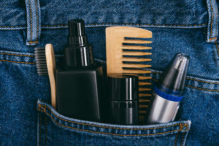 Men self care beauty kit, male beauty care cosmetic products and devices in blue jeans denim pocket. Man self care set with skin and hair care products.の写真素材