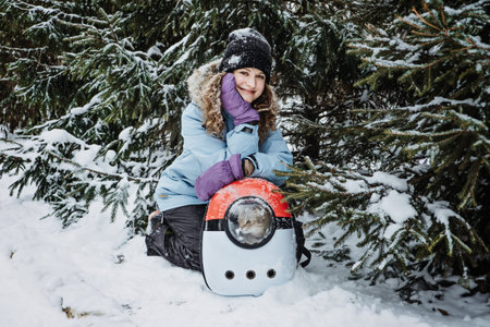 Young woman walk with Cat in Pet Carrier Backpack in winter park, forest. Bubble Backpack Carrier...