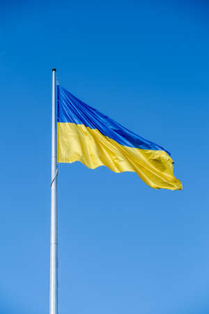 Ukrainian flag in the wind on blue sky background. Large national yellow blue flag of Ukraine. Big Ukrainian state bannerの写真素材