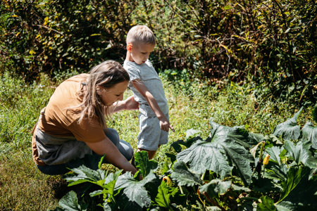 Green Thumbs, Spring is here, home gardens and picking vegetables. Happy family, mom and kid picking...