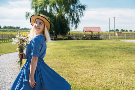Cottages at Summer Village, Vacation Rentals. Domestic Travel, Local Travel, Summer Country Travel. Countryside Getaways. Young woman in straw hat enjoys summer vacation at the farmの写真素材