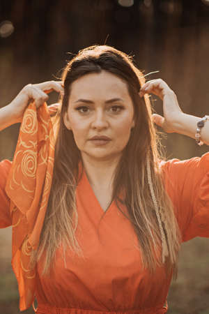 Outdoor portrait of beautiful woman in sunlight. Smiling relaxing woman with boho hair styleの写真素材