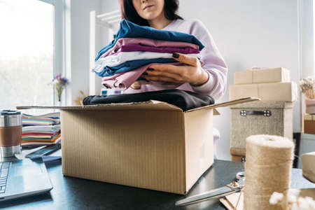 Small business owner woman packs the goods in eco packaging in office, shop.の写真素材