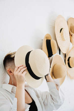Hipster modern woman and many Straw hats like interior decorate the walls in apartmentの写真素材