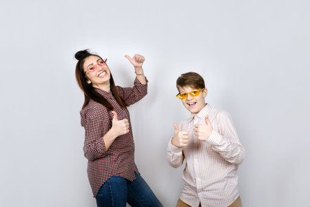 Studio Portrait of happy family mom and teenager son boy in colored glasses having fun