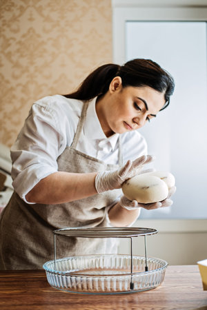 Central Asian Arabic woman pastry chef making Mirror Glaze Mousse cake. Female Middle East...