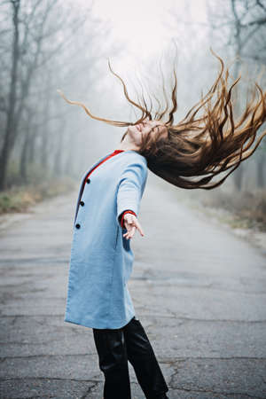 Alone Young woman with long fluttering hair express emotions in forestの写真素材