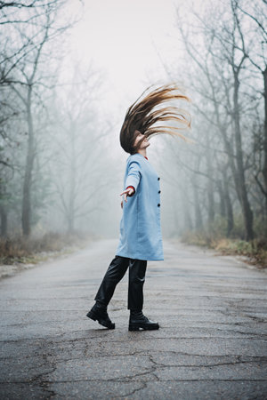 Alone Young woman with long fluttering hair express emotions in forestの写真素材
