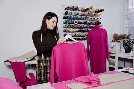 Seamstress working with sewing pattern on table in tailor shopの写真素材
