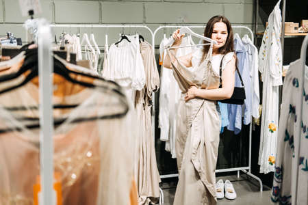 Modern Latina young woman choosing 100 percent organic cotton wear in modern eco-friendly showroom.の写真素材