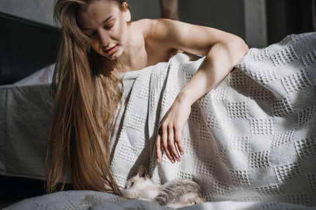 Mindfulness, Being in the present moment, here and now. Young woman play with kitten at home in morningの写真素材