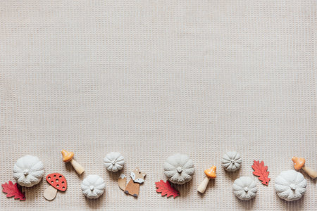 Autumn creative craft background with decorative clay pumpkins and wooden autumn leaves. Decorative pumpkins flat lay on natural fabric backgroundの写真素材
