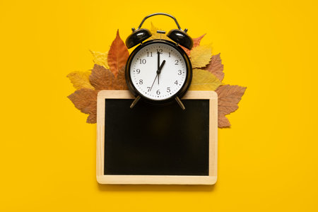 Autumn composition mockup banner with frame, dried leaves and black alarm clock on yellow...