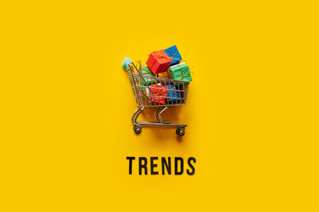 Ecommerce Retail Shopping trends concept. Word Trends and mini shopping cart with box on yellow background.の写真素材