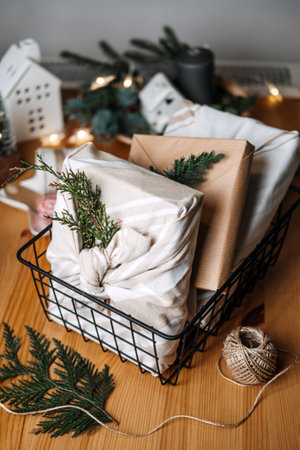 Christmas Furoshiki Japanese Fabric Wrapping gifts. Xmas Zero waste reusable eco friendly sustainable Christmas gift wrapping in linen fabric on table at homeの写真素材