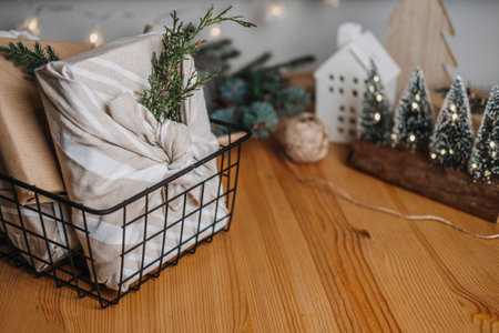 Christmas Furoshiki Japanese Fabric Wrapping gifts. Xmas Zero waste reusable eco friendly sustainable Christmas gift wrapping in linen fabric on table at homeの写真素材