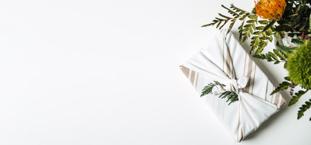 Eco friendly furoshiki wrapping cloth gift boxes. Holiday gifts christmas background with Furoshiki gift boxes wrapping in zero waste style and green plant bouquet web bannerの写真素材