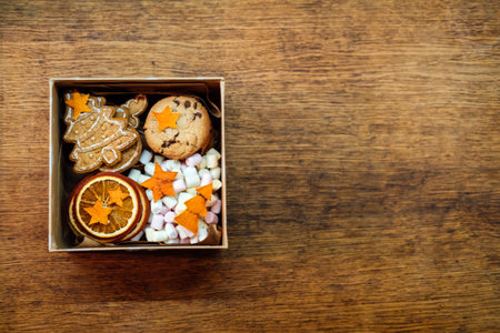 Christmas Homemade Sweet Hampers. Christmas Sweet Gift Box. Festive treats Gift Hamper Idea for Adults and Kids. Box with Homemade different cookies and orange slicesの写真素材