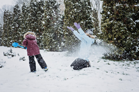 Happy Family, mother and son having fun outdoors in winter snowy nature background. Mom and kid playing snow ball at winter park outdoorsの写真素材