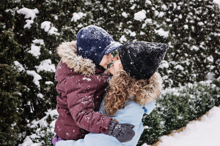 Portrait of happy family mother and son in snowy winter park. Outdoors Portrait of mom and kid boy...