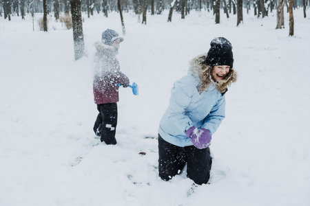 Outdoor winter activities for kids and family. Let it snow. Happy family Mom and kid boy having fun,...