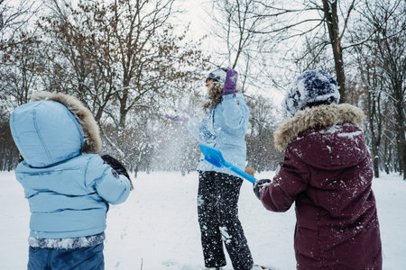 Happy Family, friends, mother and kids having fun outdoors in winter snowy nature background. Mom...
