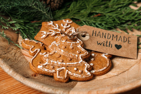 No Gift Christmas Ideas for Family, Friends For An Anti-Consumerist Christmas. Xmas homemade gingerbread cookies with ribbon, fir-tree and Handmade with love label on wooden tableの写真素材