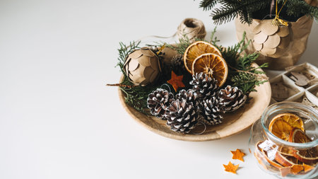 Natural Eco friendly Christmas Tree Decorations. Zero waste sustainable Xmas Tree Ornament Hanging Decorations. Christmas Tree and dry orange Slices, snow Christmas Pine Cones Ornament on tableの写真素材