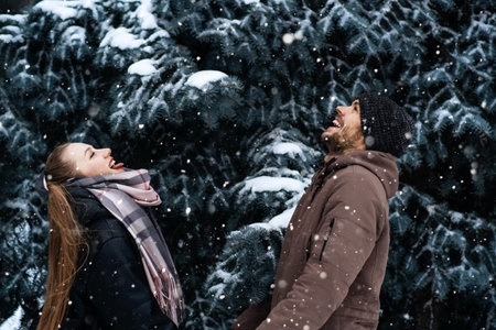 Winter Date Ideas to Cozy Up. Cheap First-Date Ideas for Winter Love dating outdoors. Cold season dates for couples. Young couple in love hugging and kissing in winter street and park.の写真素材