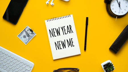 New year new me text in open notepad on yellow background. Setting goals and new years resolution. New year loading.の写真素材