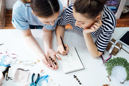 Money making crafts do at home, how to make money crafting. Small local business. Two Female jewelry artists making jewelry. Two business owner women designing jewelry in workshop, studioの写真素材