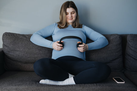 Pregnancy music for the unborn baby. Brain development. Pregnant woman with headphones on her belly...