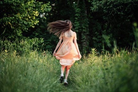 Celebrate Earth Month, Earth Day. Spend time in nature. Connect to nature is way to mitigate climate anxiety. Young woman, girl walks outdoors and enjoys natureの写真素材