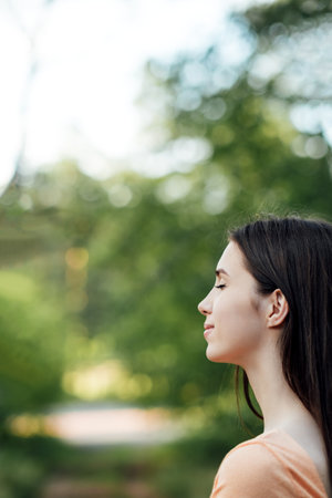 Practice Self-Care Outdoors. Connection to Nature into Daily Routine. Ground Yourself by Connecting with the Earth. Outdoors portrait of young woman enjoying natureの写真素材