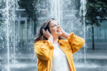 Mind-body positivity taking care of both the mind and body. practices such as meditation, yoga, and self-care to promote self-love and acceptance. Outdoor portrait of Woman in headsetの写真素材