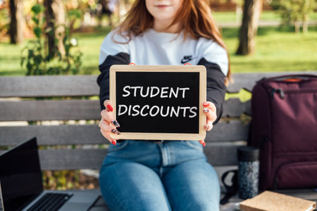 Student Discounts and student deals. Student discount is offer on product or service exclusively for students studying at school, college or university. Student hands with discount signの写真素材