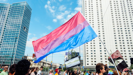 Pride month and inclusivity, support of LGBTQ. LGBT rainbow flags being waved in the air at a pride event. Wave LGBTQ gay pride flags. Equality Parade. Warsaw, Poland, June 25, 2022のeditorial素材
