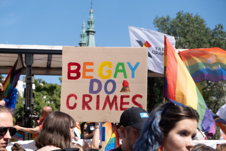 Gay pride, LGBTQ solidarity march with rainbow flags and posters. Hands holding a poster with text be gay do crimes. Equality Parade. Warsaw, Poland, June 25, 2022のeditorial素材