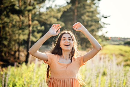 Positive emotions like happiness, excitement, joy, hope, and inspiration is vital for happy and healthy life. Outdoor portrait of happy smiling young woman in nature backgroundの写真素材