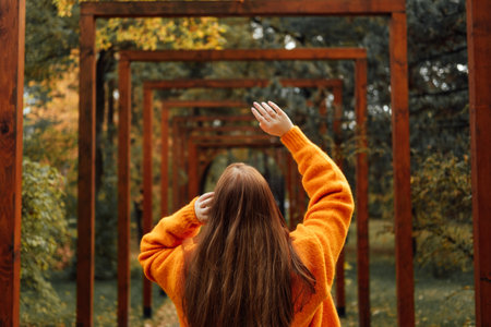 Autumn wellbeing, ways to protect your mental health during darker months. Mental wellness in the fall. Back view of beautiful redhead woman with perspective fall autumn nature park background.の写真素材