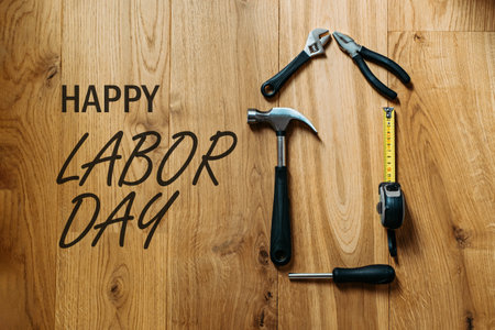Happy labor day banner with different construction tools on wooden background. Construction and manufacturing tools on wooden background. Labor day background concept.の写真素材
