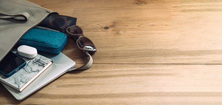 Travel Essentials Pack For Trip, Things Pack In Carry-On. Packing list for Airplane Tote. Female Carry-On luggage tote bag with laptop, notepad, glasses, headphones, cosmeticsの写真素材