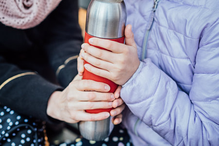 Creative Kid-Friendly Picnic Ideas For Autumn. Happy mother with teenager daughter with blanket and thermos on fall picnic. Mom and daughter picnic in the autumn parkの写真素材