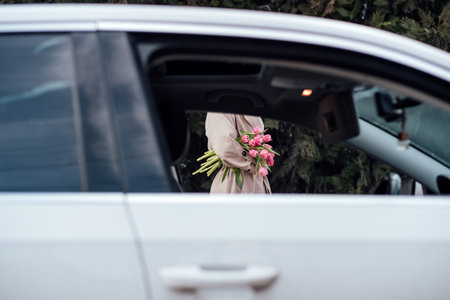 Floral Delivery Services. Order online and get fresh flower special delivery. Faceless woman with bouquet of pink tulip flowers, view from Car Window.の写真素材