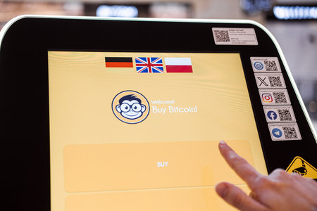 Warsaw, Poland - March 19, 2024. Person Using Bitcoin ATM for Cryptocurrencyのeditorial素材